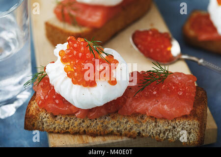 Sunday breakfast with poached egg, caviar and red fish Stock Photo