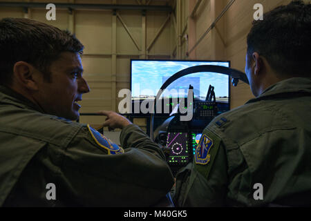 A U.S. Air Force instructor pilot assigned to the 81st Fighter Squadron, Moody Air Force Base, Georgia, reviews the flight after an Afghan student pilot landed in the A-29 Super Tucano flight simulator. Students work with their U.S. instructors to build familiarity and proficiency in the simulator before flying the A-29. The A-29 is a two-seat aircraft, allowing students to fly with U.S. instructor pilots in the back seat. The American instructor pilot can take control of the aircraft at any time, but the students are expected to fly the aircraft through the entire mission. (U.S. Air Force pho Stock Photo