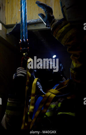 USAF Senior Airman Steven Dorsey, a firefighter with the 86th Civil Engineering Squadron, ascends up a confined quarter’s shaft during a training course at the 435th Construction and Training Squadron’s training facility outside the gates of Ramstein Air Base, Germany on 19 Feb. 2015. The confined quarters training was part of a three week course that allows firefighters to utilize advanced harnessing and rope techniques in order to possibly save lives. (DoD News photo by SSgt Brian Kimball) 150220-F-QP401-213 by DoD News Photos Stock Photo