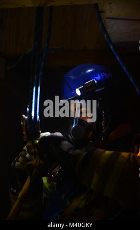 USAF Senior Airman Steven Dorsey, a firefighter with the 86th Civil Engineering Squadron, prepares to ascend up a confined quarter’s shaft during a training course at the 435th Construction and Training Squadron’s training facility outside the gates of Ramstein Air Base, Germany on 19 Feb. 2015. The confined quarters training was part of a three week course that allows firefighters to utilize advanced harnessing and rope techniques in order to possibly save lives. (DoD News photo by SSgt Brian Kimball) 150220-F-QP401-217 by DoD News Photos Stock Photo
