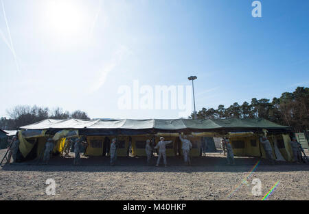 Members of the 212th Combat Support Hospital (CSH) build a fully functional field hospital at Miesau Army Depot, Germany on April 14, 2015. The 212th CSH field hospital was built in order to better prepare the unit for real world scenarios where rapid deployable hospitals are required. (DoD News photo by SSgt Brian Kimball) (DoD News photo by SSgt Brian Kimball) 150414-F-QP401-004 by DoD News Photos Stock Photo