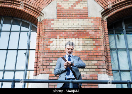 Mature businessman standing in a city. Stock Photo