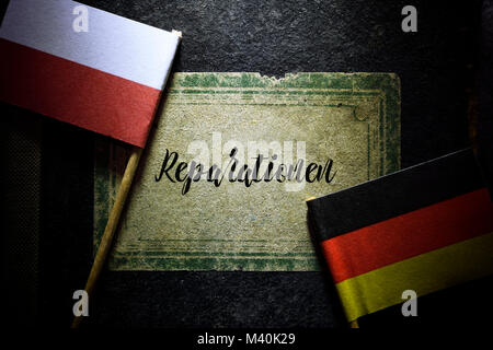 Flags of Germany and Poland and book with the inscription reparations, Fahnen von Deutschland und Polen und Buch mit der Aufschrift Reparationen Stock Photo