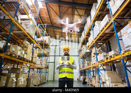 Man with drone in a warehouse. Stock Photo