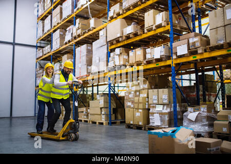 Two young workers in a warehouse. Stock Photo