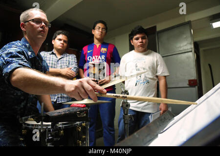 150623-A-ZA034-096 SAN SALVADOR, El Salvador (June 23, 2015) Musician 1st Class Gabe Giannelli a native of Norfolk, Va., assigned to the Fleet Forces Band, Uncharted Waters, teaches a drum lesson to students during a community relations event in support of Continuing Promise 2015. Continuing Promise is a U.S. Southern Command-sponsored and U.S. Naval Forces Southern Command/U.S. 4th Fleet-conducted deployment to conduct civil-military operations including humanitarian-civil assistance, subject matter expert exchanges, medical, dental, veterinary and engineering support and disaster response to Stock Photo