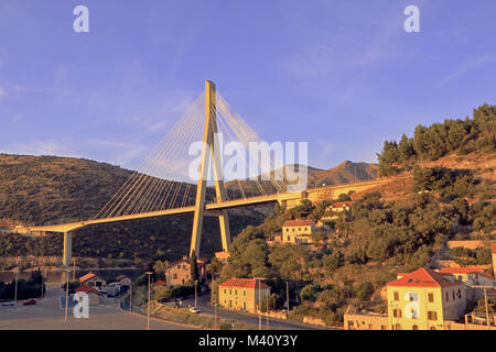 The setting sun shining on the Franjo Tudman Bridge. The bridge is a cable-stayed bridge crossing the D8 State Road over the Dubrovacka coastal inlet Stock Photo