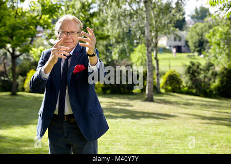 Portrait of gesticulate man in the garden at sunny day. Natural sunlight. Stock Photo