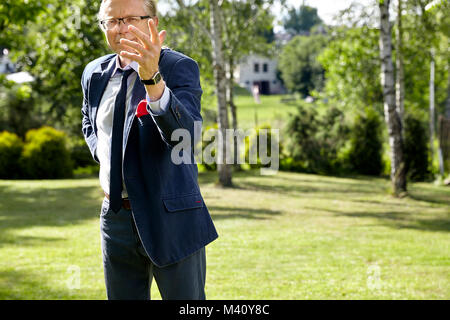 Portrait of gesticulate man in the garden at sunny day. Natural sunlight. Stock Photo