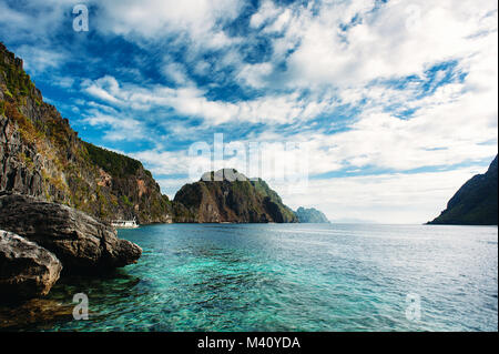 El Nido, Palawan, Philippines. Sharp rocks in lagoon. Blue sky with clouds and clear sea water. Stock Photo