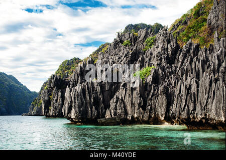 El Nido, Palawan, Philippines. Sharp rocks in lagoon. Blue sky with clouds and clear sea water. Stock Photo