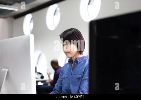 Asian businesswoman working on a desktop computer Stock Photo
