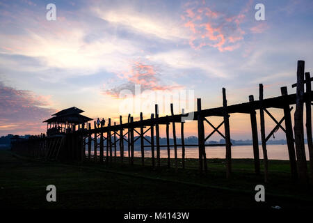 U Bein Bridge, an old teakwood bridge, is spanning over Taungthaman Lake before sunrise Stock Photo