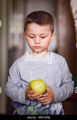 Cute little boy holding an apple Stock Photo