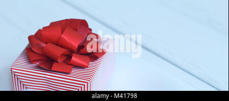 gift box with red bow and hearts on light background Stock Photo