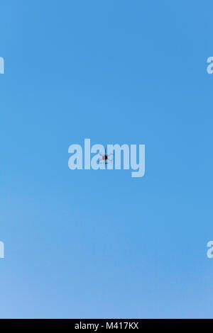Drone hovering against clear blue sky Stock Photo