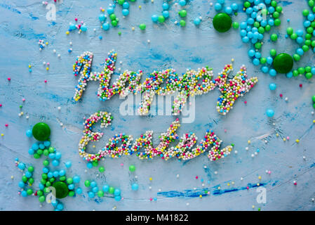 Words Happy Easter made of colorful candies on blue pastel background Stock Photo
