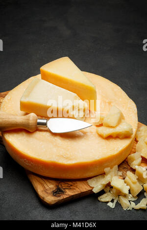 Whole round Head of parmesan or parmigiano hard cheese on concrete background Stock Photo