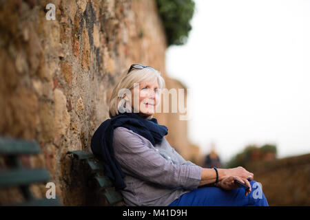 Senior woman relaxing on a bench Stock Photo