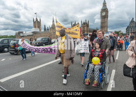 Disabled People Against the Cuts supporters incouding Lewisham People Before Profit and Winvisible block traffic on Westminster Bridge on Budget Day in protest against cuts hitting the disabled. Stock Photo