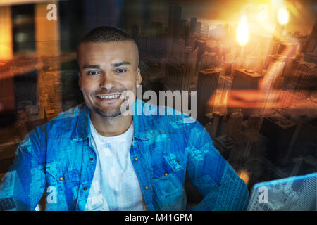 Handsome man smiling and looking glad while waiting for his girlfriend Stock Photo