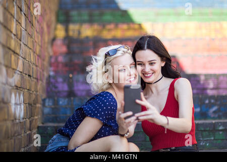 Female friends taking selfie in urban city Stock Photo