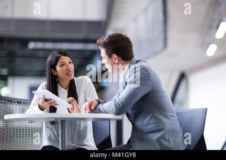 Colleagues in an informal business meeting using a digital tablet Stock Photo