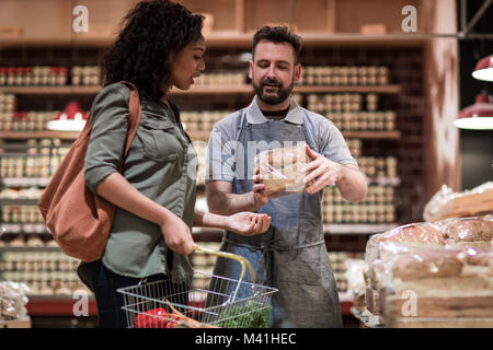 Baker helping customer in grocery store Stock Photo