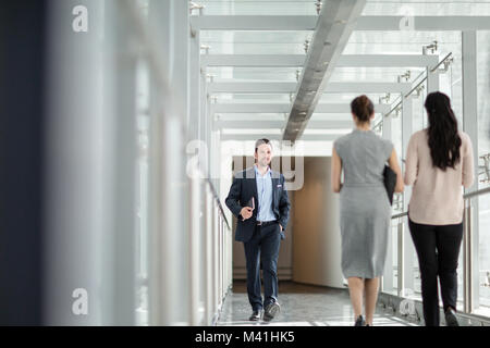Businessman walking through office corridor Stock Photo