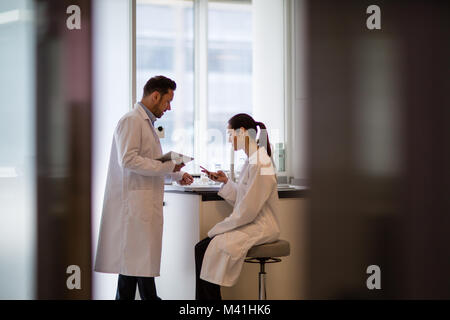 Female scientist discussing results of experiment with male colleague Stock Photo