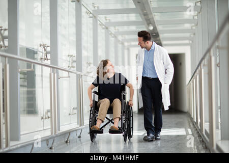 Woman in wheelchair talking with medical professional Stock Photo