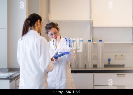 Two female scientists discussing results of experiment Stock Photo