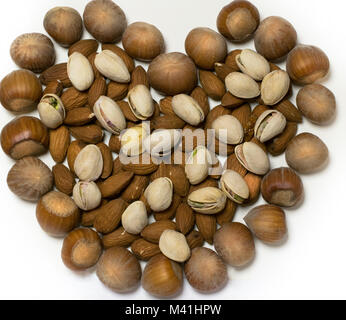 Nuts collection in the shape of a heart, hazelnuts, pistachio, almonds and nuts on a white background, isolated, Valentine's Day Stock Photo