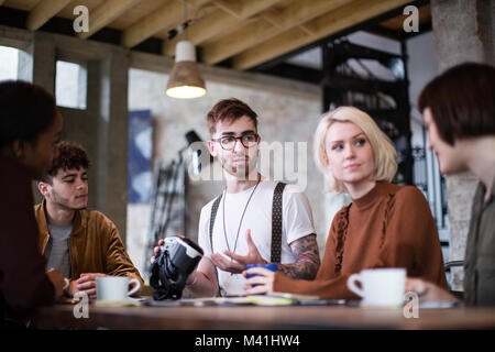 Group of young entrepreneurs in a meeting with VR headset Stock Photo