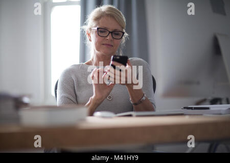 Mature businesswoman using smartphone Stock Photo