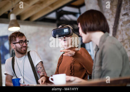 Group of young entrepreneurs in a meeting with VR headset Stock Photo