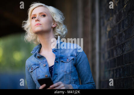 Young adult female using smartphone on street Stock Photo