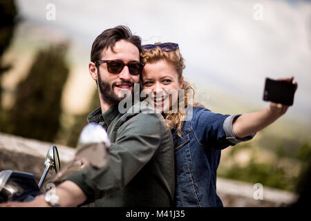 Young couple on motorbike taking a selfie Stock Photo
