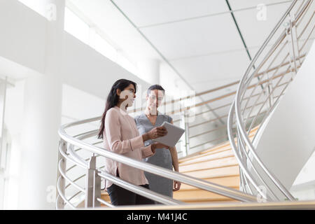 Business colleagues looking at digital tablet together Stock Photo