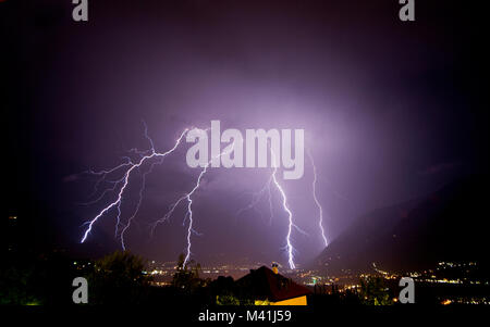 A strong thunderstorm discharge many lightning on the Meran city, during the night. Passiria Valley, Trentino Alto Adige, Italy Stock Photo