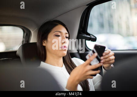 Businesswoman paying via app for taxi cab ride Stock Photo