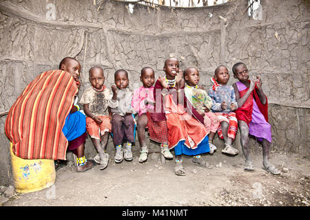 AFRICA, TANZANIA-FEBRUARY 9, 2014: Portrait on an African Kids of Masai  tribe village smiling to the camera, playing in kindergarten made with cow du Stock Photo