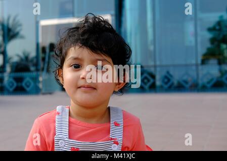 Close up head shot of Healthy Kid posing for the camera in front of shopping mall Stock Photo