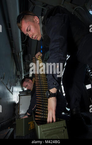 180209-N-NB544-031 GULF OF THAILAND (Feb. 9, 2018) Gunner's Mate Seaman Cole Parrish, front, from Prescott Valley, Ariz., and Gunner's Mate Seaman Michael Norris, from Oakdale, Calif., store rounds of .50-caliber machine gun ammunition during small craft action team (SCAT) training aboard the amphibious assault ship USS Bonhomme Richard (LHD 6). Bonhomme Richard is operating in the Indo-Asia-Pacific region as part of a regularly scheduled patrol and provides a rapid-response capability in the event of a regional contingency or natural disaster. (U.S. Navy photo by Mass Communication Specialist Stock Photo