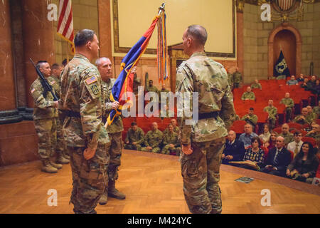 Brig. Gen. Gordon L. Ellis receives the 38th Infantry Division flag during the unit’s change of command ceremony in Indianapolis, Sunday, Feb. 11, 2018. Ellis took the reins of the division from Maj. Gen. David C. Wood, who had led the division since October 2014. “As I assume command, I am cognizant of the need to continue to build sustained readiness across the formation of this division,” said Ellis during his speech. Photo by Sgt. Diana Richardson, 38th Infantry Division Unit Public Affairs Representative Stock Photo