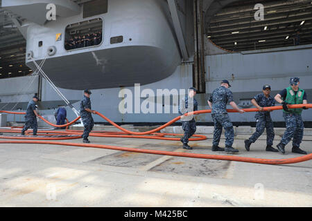 170725-N-NN369-151  NORFOLK (JULY 25, 2017) Sailors assigned to the Nimitz-class aircraft carrier USS Abraham Lincoln (CVN 72), handle power cables for the Nimitz-class aircraft carrier USS Harry S. Truman (CVN 75), as Harry S. Truman pulls into Naval Station Norfolk after completing Sea Trials. Abraham Lincoln is moored in Norfolk for a carrier incremental availability in preparation for workups. (U.S. Navy photo by Mass Communication Specialist 3rd Class Jessica Paulauskas/Released) Stock Photo