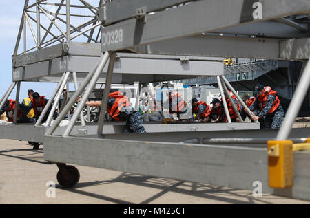 170725-N-NN369-178  NORFOLK (JULY 25, 2017) Sailors assigned to the Nimitz-class aircraft carrier USS Abraham Lincoln (CVN 72), handle power cables for the Nimitz-class aircraft carrier USS Harry S. Truman (CVN 75), as Harry S. Truman pulls into Naval Station Norfolk after completing Sea Trials. Abraham Lincoln is moored in Norfolk for a carrier incremental availability in preparation for workups. (U.S. Navy photo by Mass Communication Specialist 3rd Class Jessica Paulauskas/Released) Stock Photo