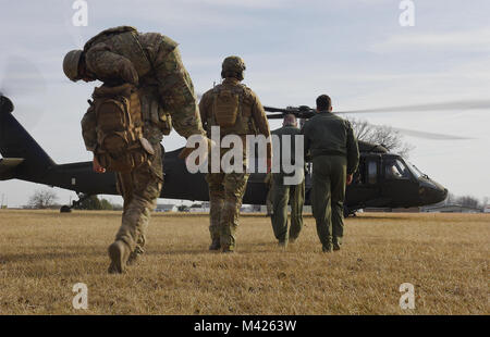 U.S. Air Force Tactical Air Control Party specialists assigned to the 7th Air Support Operations Squadron located in Fort Bliss, Texas, and pilots assigned to Whiteman Air Force Base, Mo., board a UH-60 Black Hawk assigned to Whiteman on Jan. 31, 2018, in Lincoln, Mo. The 1-135th Assault Helicopter Battalion and Whiteman pilots trained with Joint Terminal Attack Controllers to build a partnership while understanding each other’s capabilities. (U.S. Air Force photo by Airman 1st Class Taylor Phifer) Stock Photo