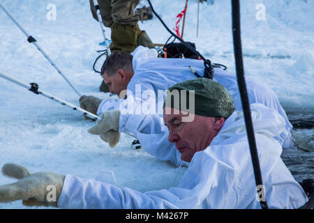 Norwegian Maj.Gen. Odin Johannessen, the chief of Norwegian Army, participates in an ice-breaking drill alongside Maj.Gen. Russell A.C. Sanborn, the commander of Marine Corps Forces Europe and Africa, in Bardufoss, Norway, Jan. 31, 2018. Sanborn participated in this training evolution to experience the training the Marines have endured throughout their time in Norway. The drill is a cornerstone of advanced cold-weather training, intended to teach a service member the immediate steps to take when falling in ice.  (U.S. Marine Corps photo by Cpl. Careaf L. Henson/Released) Stock Photo