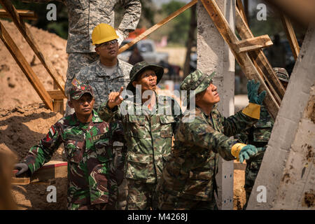 Royal Thai, Indonesian, and U.S. Armed Forces service members guide the main pillar into place during a pillar raising ceremony for the construction of a school building at Banthungsohongsa School in support of Exercise Cobra Gold 2018 in Chachoengsao, Kingdom of Thailand, Jan. 31, 2018. Humanitarian Civic Assistance projects conducted during the exercise support the needs and humanitarian interests of the Thai people. Cobra Gold 18 is an annual exercise conducted in the Kingdom of Thailand and runs from Feb. 13-23 with seven full participating nations. (U.S. Marine Corps photo by Sgt. Matthew Stock Photo